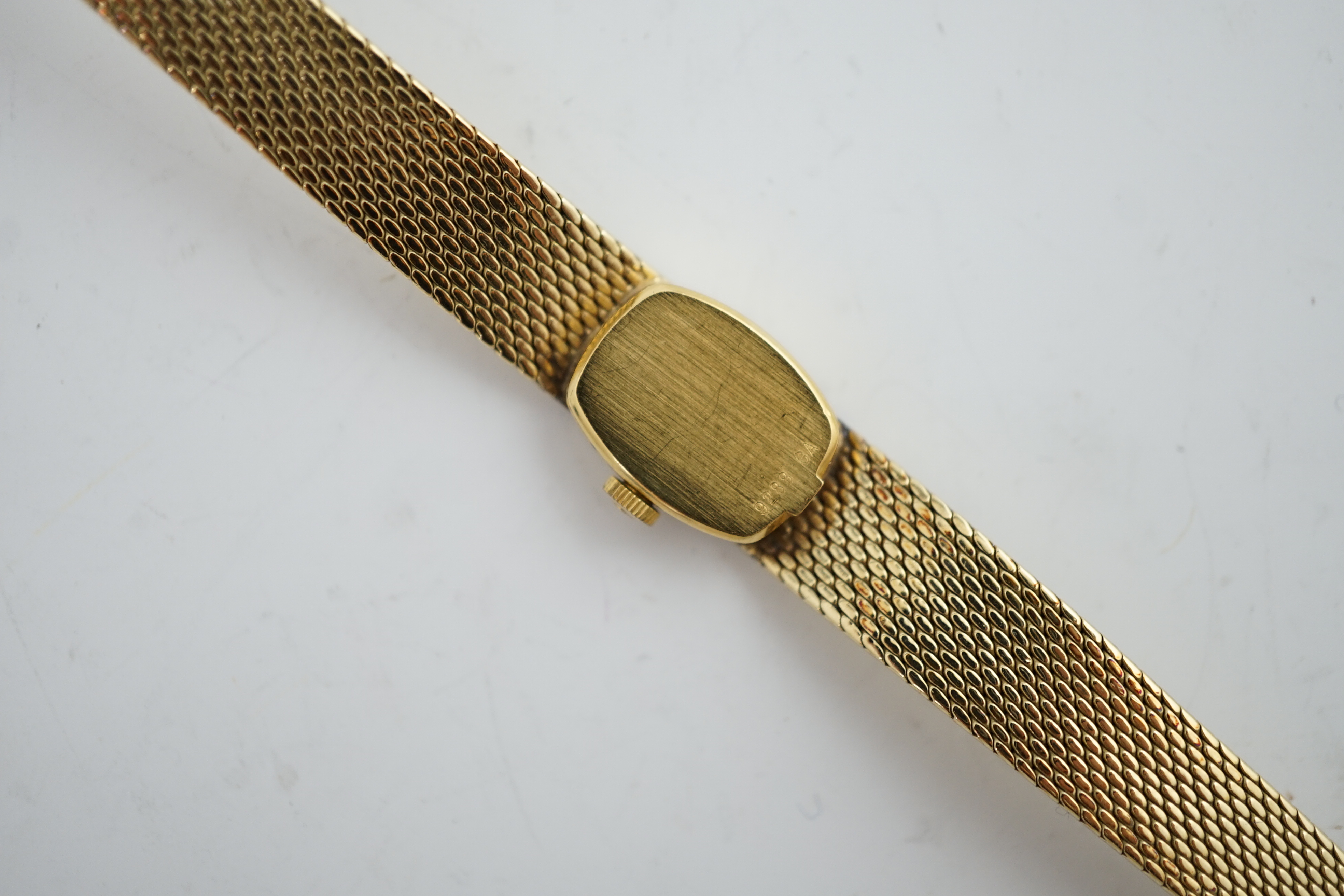 A lady's Girard Perregaux 18K cased wrist watch, with tiger's eye quartz dial, white hands and markers, on an integral yellow metal textured close-link flexible bracelet with clasp, which is stamped 18k but does not test